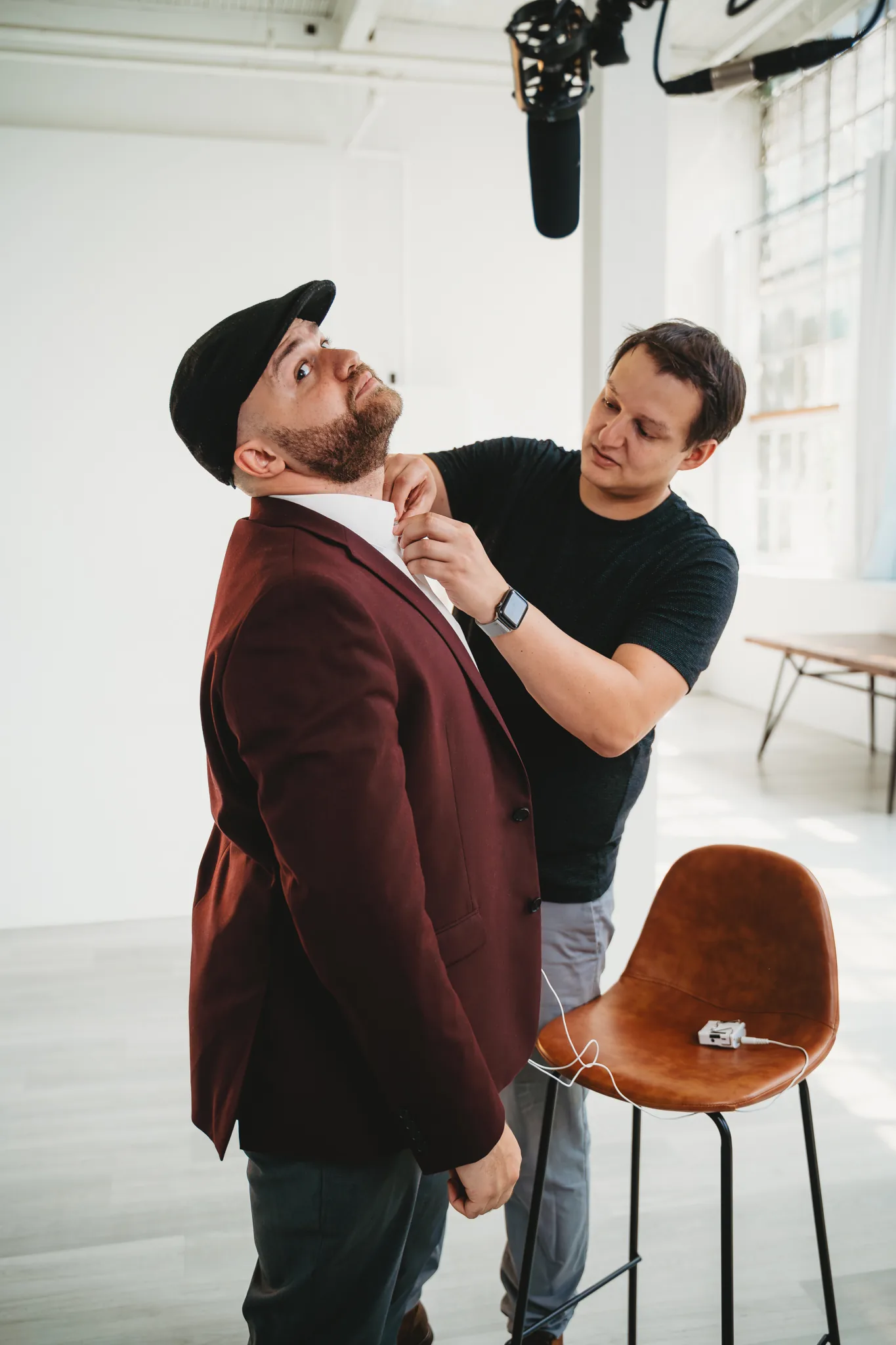 Paul adjusting Zach's collar on set